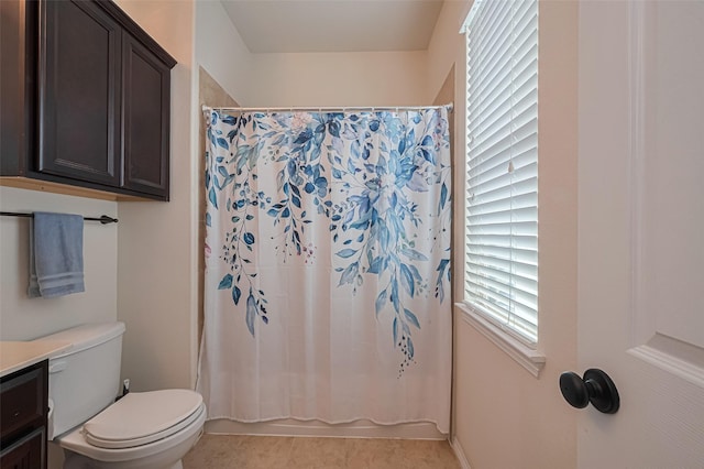 bathroom featuring vanity, plenty of natural light, toilet, and tile patterned flooring