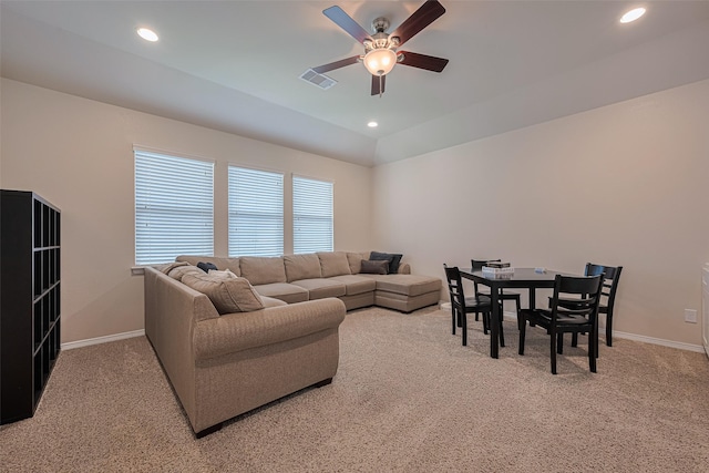 living area with visible vents, a ceiling fan, baseboards, and light carpet