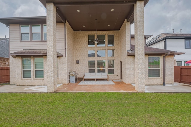back of house with a lawn, brick siding, fence, and a patio area