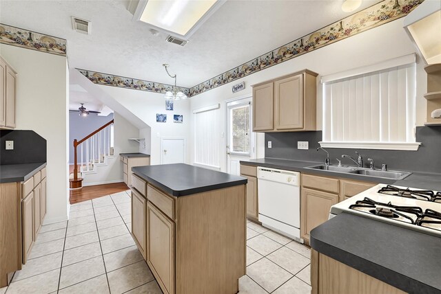 3006 Eagle Nest Ln, Humble, TX 77396 - kitchen featuring dishwasher, dark countertops, a sink, light brown cabinetry, and light tile patterned flooring