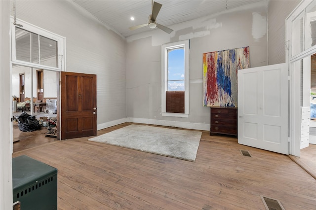 foyer featuring baseboards, visible vents, wood finished floors, and a ceiling fan