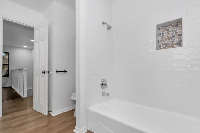 full bath with baseboards, wood finished floors, toilet, and  shower combination