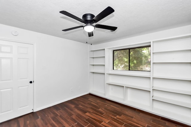 spare room with a textured ceiling, ceiling fan, dark wood finished floors, and baseboards