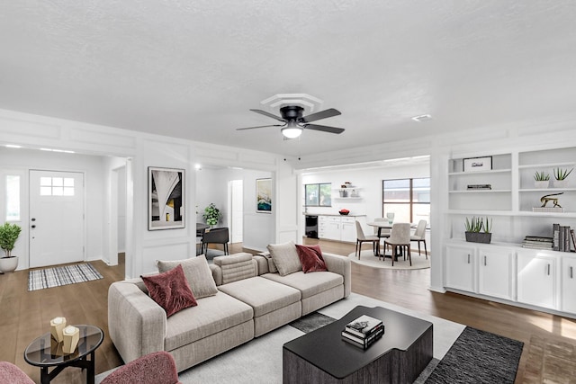 living room featuring a wealth of natural light, wood finished floors, and a ceiling fan