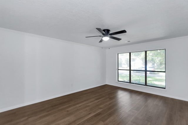spare room with baseboards, a ceiling fan, dark wood-style flooring, and crown molding