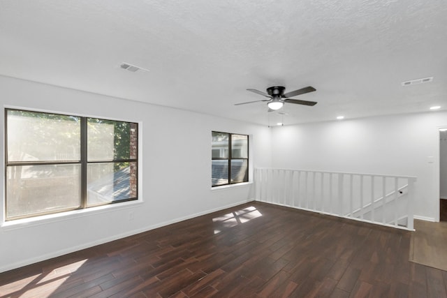 empty room featuring visible vents, ceiling fan, wood finished floors, and baseboards