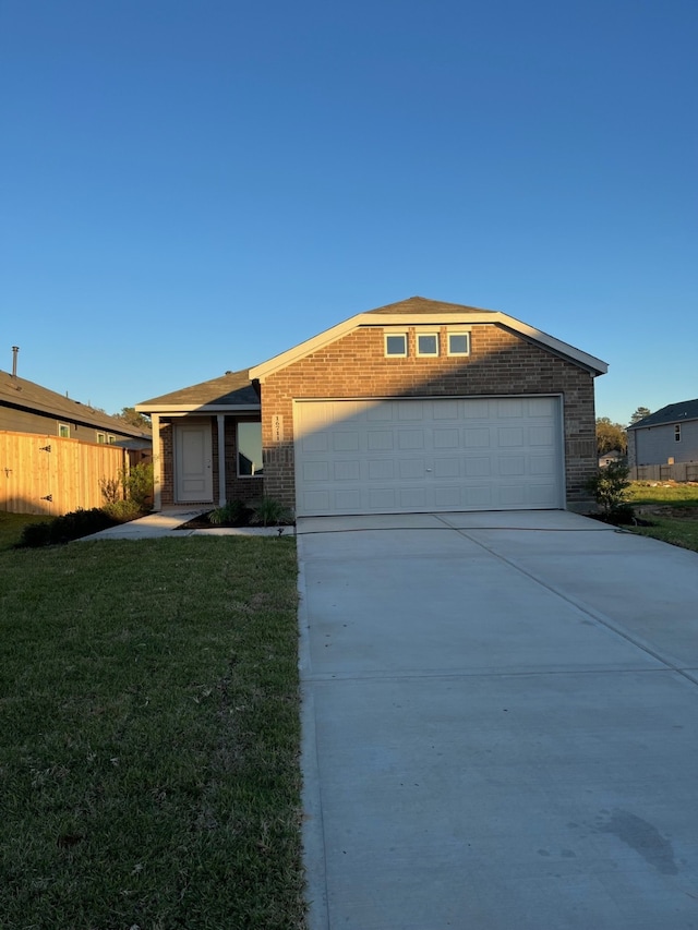 single story home featuring brick siding, fence, a garage, driveway, and a front lawn