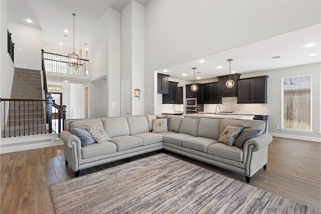 living area featuring a healthy amount of sunlight, stairway, and dark wood finished floors