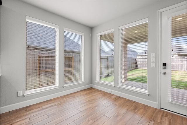 unfurnished dining area featuring wood finished floors and baseboards
