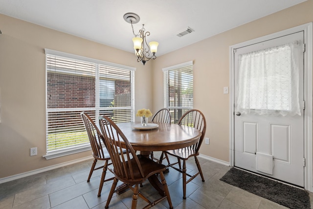 tiled dining room featuring an inviting chandelier, visible vents, and baseboards