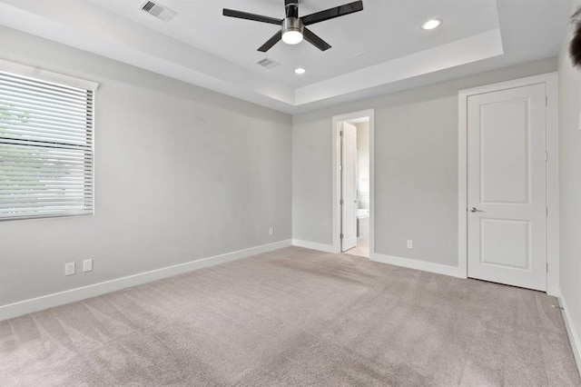 unfurnished bedroom featuring a raised ceiling, visible vents, carpet flooring, and baseboards