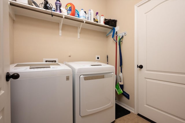 laundry room with light tile patterned flooring, separate washer and dryer, and laundry area