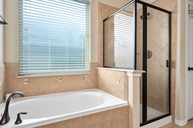 bathroom with a healthy amount of sunlight, a shower stall, and a bath