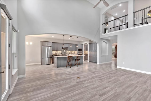 461 Pine Forest Acres Dr, Trinity, TX 75862 - living area with a ceiling fan, arched walkways, baseboards, and a high ceiling