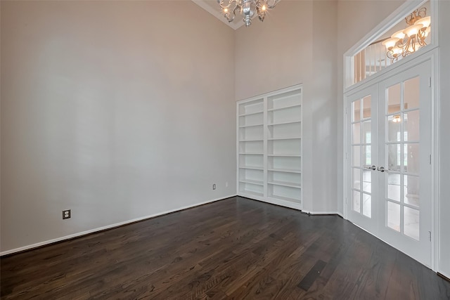 interior space with a notable chandelier, built in features, dark wood-type flooring, and a towering ceiling