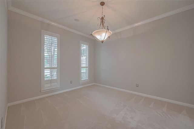 spare room featuring light colored carpet, ornamental molding, and baseboards
