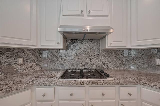 kitchen featuring light countertops, tasteful backsplash, stainless steel gas stovetop, and white cabinetry