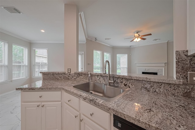 kitchen featuring light stone countertops, marble finish floor, ceiling fan, a sink, and visible vents