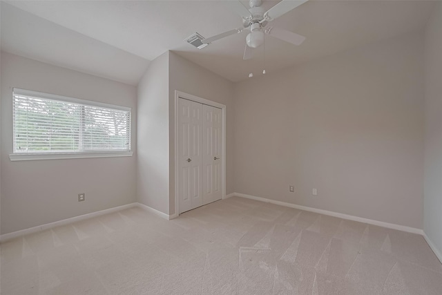 unfurnished bedroom with a closet, visible vents, light colored carpet, and baseboards