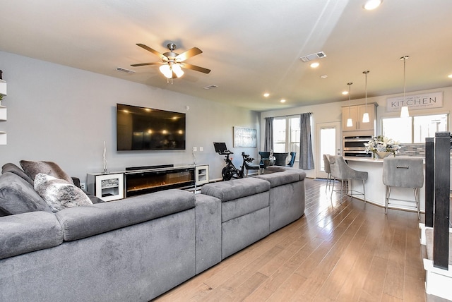 living area featuring recessed lighting, a ceiling fan, visible vents, and light wood-style floors