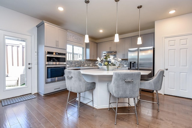 kitchen featuring gray cabinetry, tasteful backsplash, appliances with stainless steel finishes, and a kitchen island