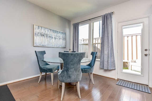 dining space featuring baseboards, visible vents, and wood finished floors