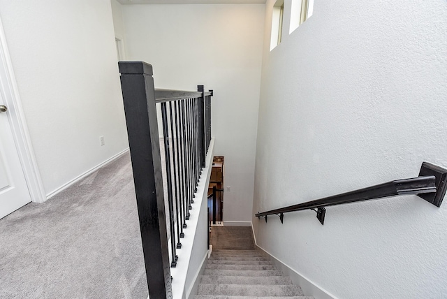 stairs featuring carpet flooring and baseboards