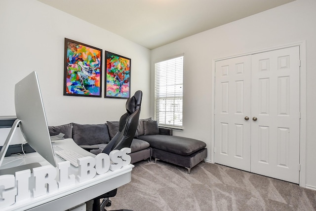 carpeted living area featuring baseboards