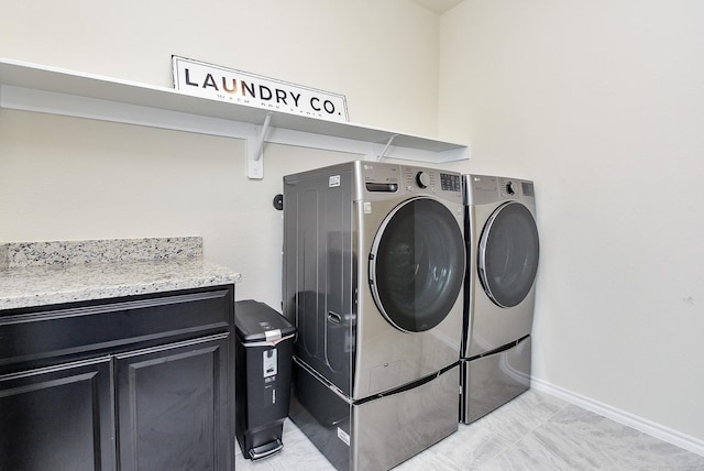 laundry area with independent washer and dryer and baseboards