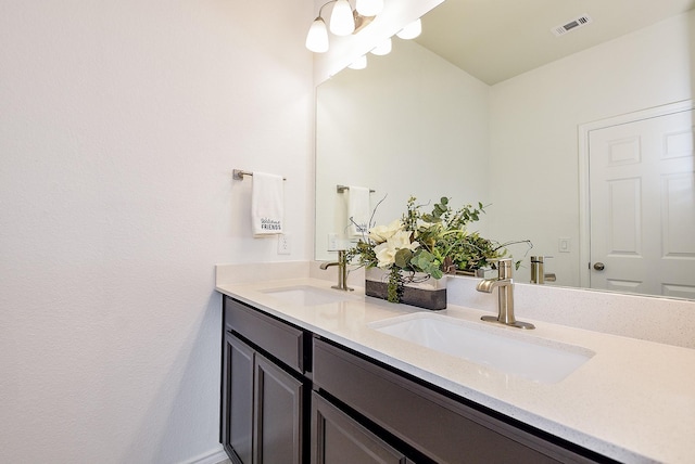 bathroom with visible vents, double vanity, and a sink
