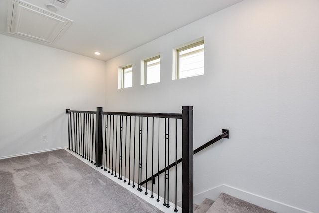 stairway with baseboards, attic access, and carpet flooring