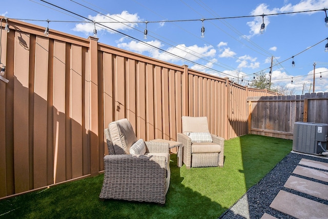 view of yard with central air condition unit and a fenced backyard