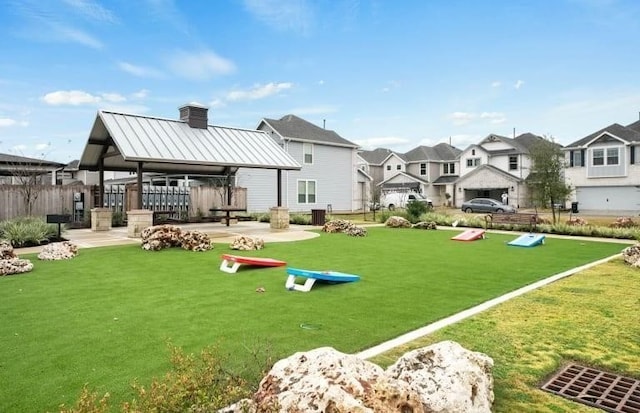 view of community featuring a residential view, a gazebo, a yard, and fence