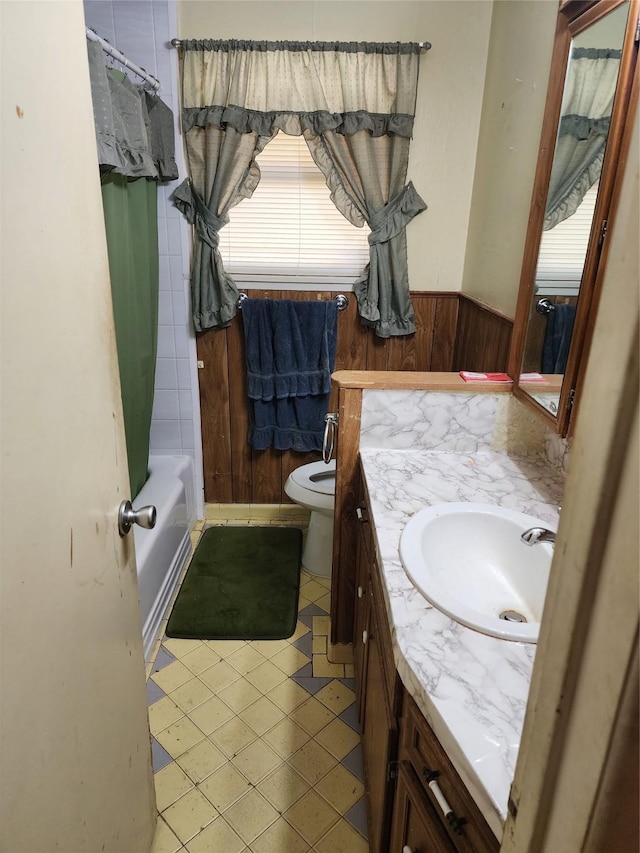918 Redondo Dr, Houston, TX 77015 - bathroom featuring vanity, toilet, wood walls, shower / bath combination with curtain, and a wainscoted wall