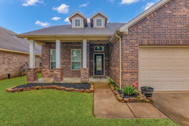 view of front of home featuring a shingled roof, covered porch, brick siding, a front lawn, and a garage