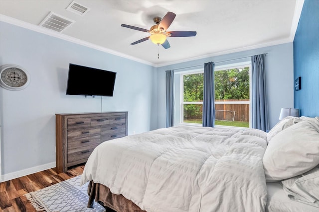 bedroom featuring crown molding, visible vents, wood finished floors, and baseboards