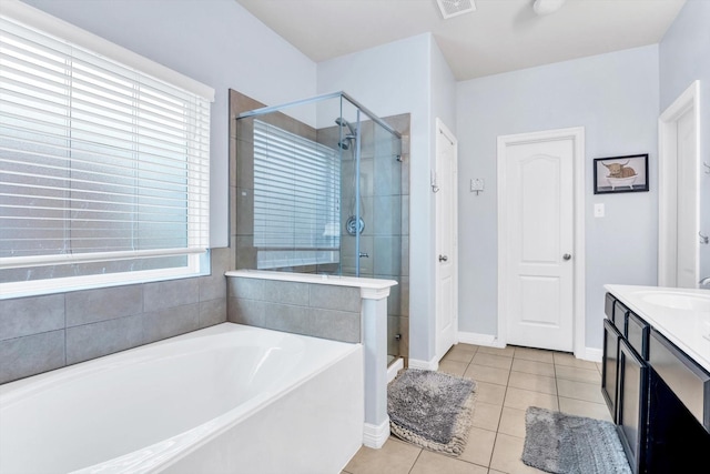 bathroom featuring a stall shower, a garden tub, vanity, and tile patterned flooring