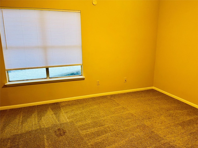 empty room with dark carpet and baseboards