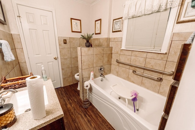5514 Pardee St, Houston, TX 77026 - full bathroom with ornamental molding, wood finished floors, toilet, tile walls, and a bath