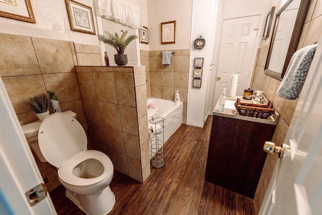 5514 Pardee St, Houston, TX 77026 - full bath with a garden tub, vanity, wood finished floors, toilet, and tile walls