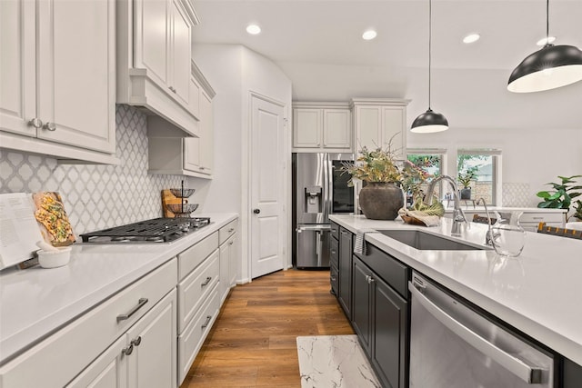 kitchen featuring light countertops, stainless steel appliances, recessed lighting, and a sink