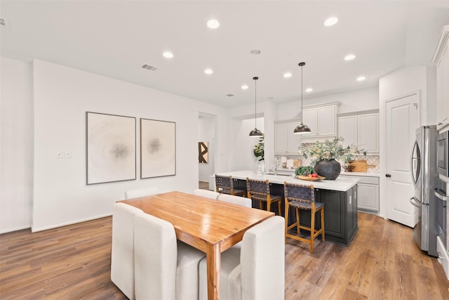 dining room with recessed lighting, visible vents, and light wood finished floors