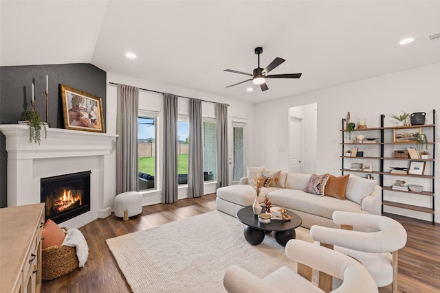 living area featuring visible vents, a glass covered fireplace, wood finished floors, recessed lighting, and a ceiling fan