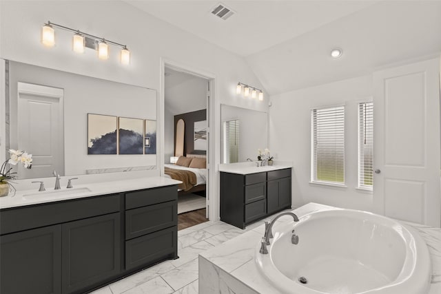 ensuite bathroom with a bath, visible vents, a sink, lofted ceiling, and ensuite bathroom