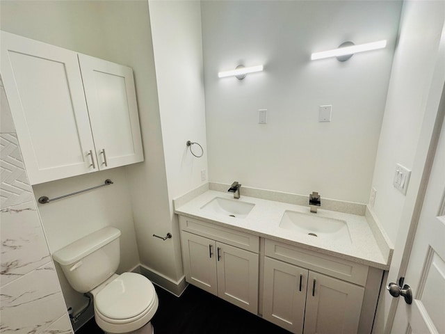 bathroom featuring double vanity, a sink, marble finish floor, and toilet