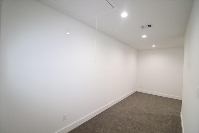 unfurnished room with visible vents, baseboards, attic access, dark colored carpet, and recessed lighting