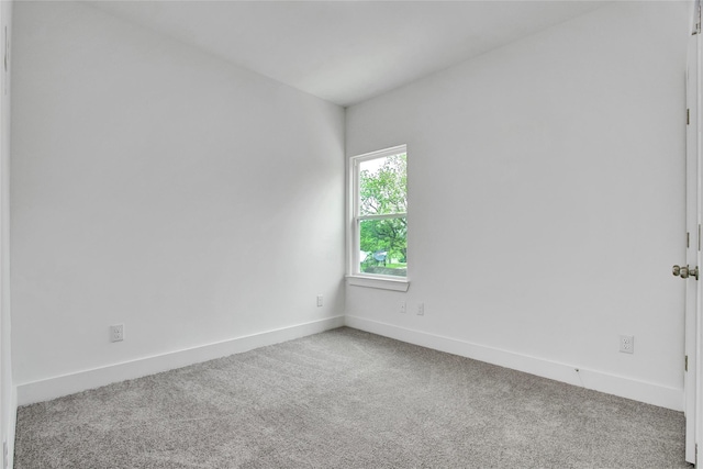unfurnished room with baseboards and carpet