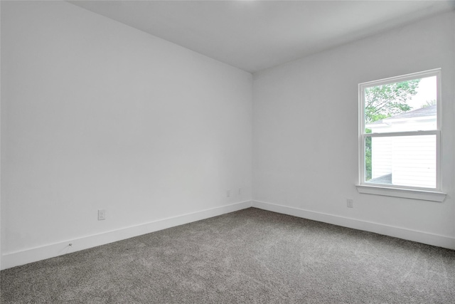 spare room featuring baseboards and carpet