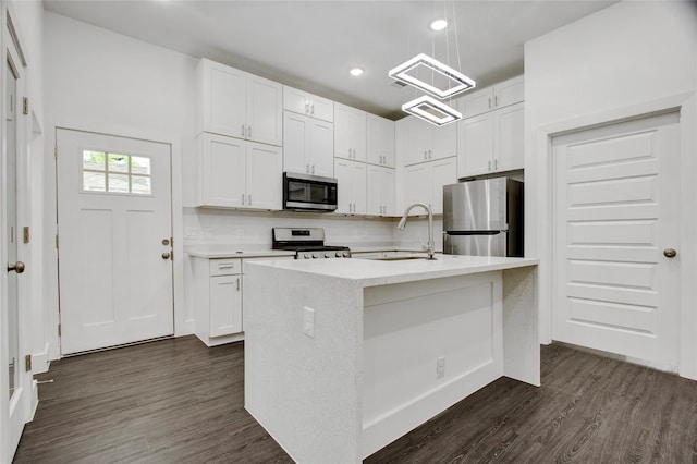 kitchen with a sink, light countertops, white cabinets, dark wood-style floors, and stainless steel appliances