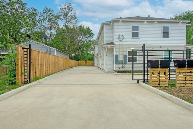 view of side of home featuring fence and driveway